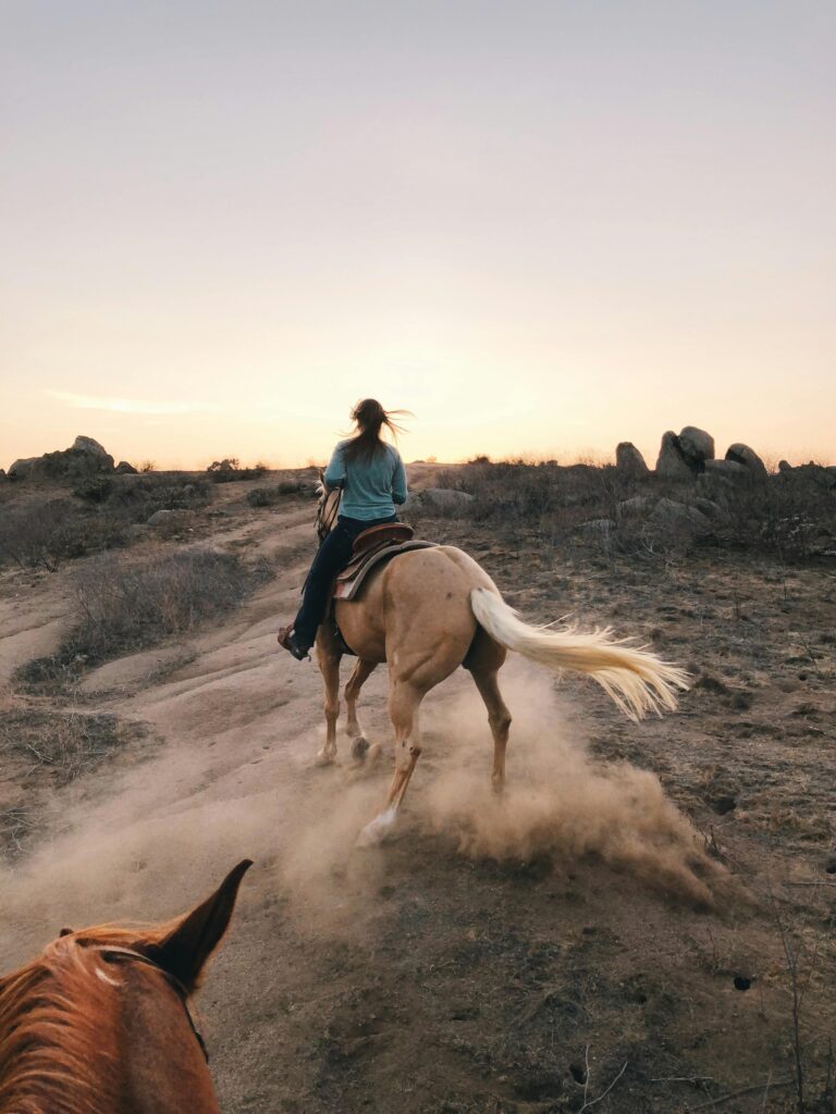 Capture the thrill of horseback riding through dusty trails in California's scenic landscape.